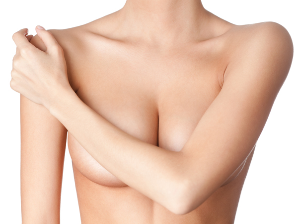 Modelo femenina desnuda con un brazo cubriendo sus pechos