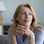 senior mature blonde woman leaning chin on hands